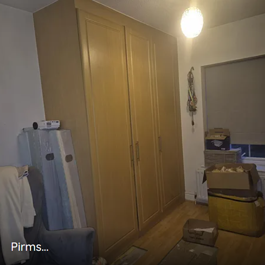 Pirms · divi lieli drēbju skapji telpas otrā galā
